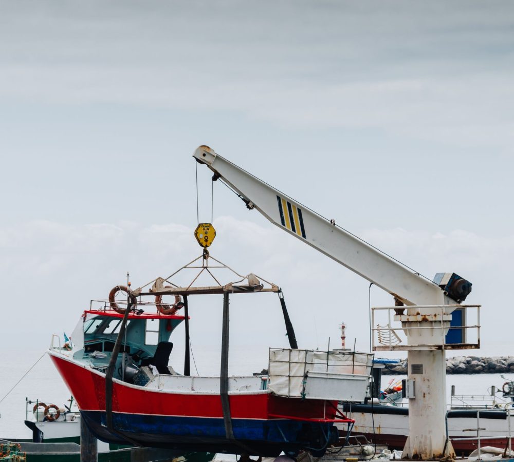 vertical-shot-crane-lifting-white-boat-pier (1)